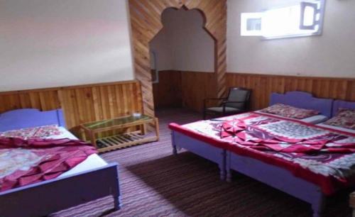 Un pat sau paturi într-o cameră la Snow Land Guest House Naran