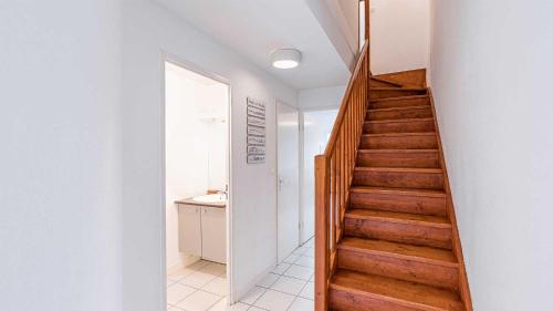 a staircase in a room with white walls and wooden floors at Madame Vacances Les Rives Marines in Le Teich