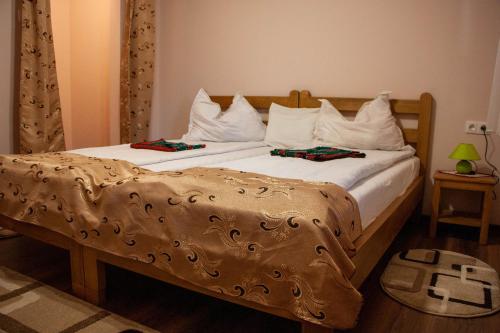 a bedroom with two beds with white pillows at Nyikó Vendégház in Lupeni