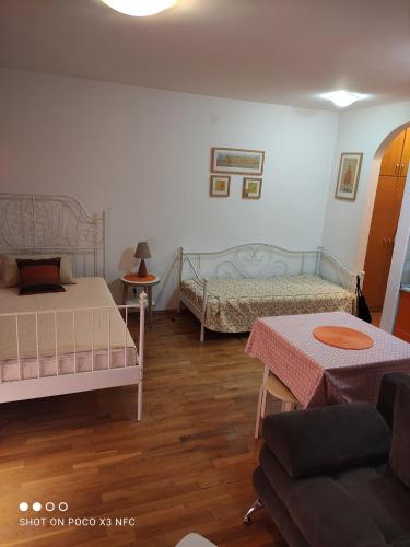 a bedroom with two beds and a couch at Apartment Mira in Petrovac na Moru