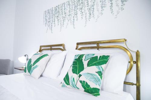 Una cama con almohadas verdes y blancas. en Villa Adele, en Torchiarolo