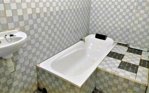 バニュワンギにあるCheap Inn Banyuwangiのバスタブと洗面台のあるバスルーム