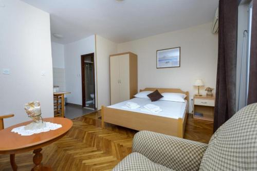 um quarto de hotel com uma cama e uma mesa em Apartments Botica em Mlini
