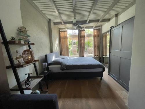 Un dormitorio con una cama y una ventana grande. en Coconut Beach apartments, en Zandvoort