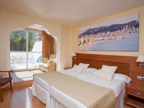 a hotel room with a bed and a large window at Magic Villa de Benidorm in Benidorm