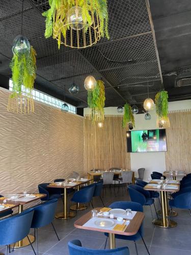 a dining room with tables and blue chairs at Le Karé Ébène in Cotonou