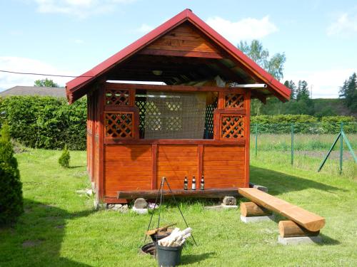 a wooden out house with a bench in the grass at Apartmán " Matej" in Smrečany