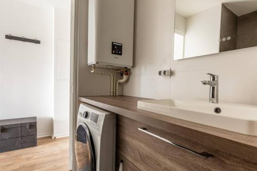 a kitchen with a sink and a washing machine at Superbe Studio à 2 Stations de Paris Centre 15min à pied du Stade de France in Saint-Denis