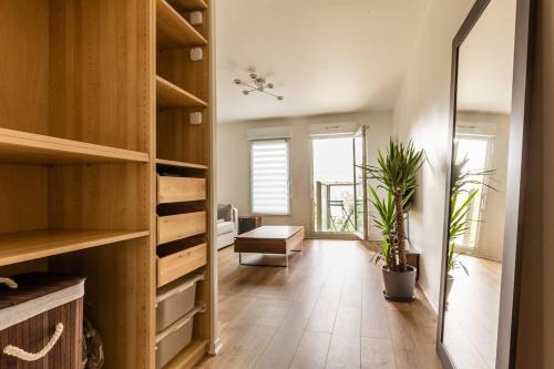 une chambre avec des armoires en bois et un couloir avec des plantes dans l'établissement Superbe Studio à 2 Stations de Paris Centre 15min à pied du Stade de France, à Saint-Denis