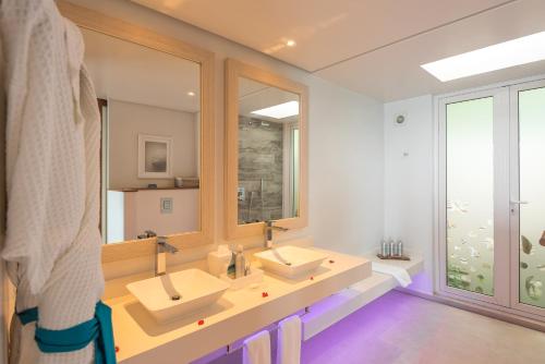 un bagno con due lavandini e un grande specchio di CaranaBeach a Glacis