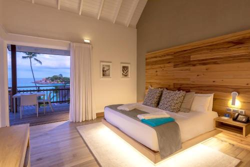a bedroom with a bed and a view of the ocean at CaranaBeach in Glacis