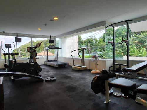 a gym with several tread machines in a room at Spacious apartment with Ocean view in Panwa in Phuket
