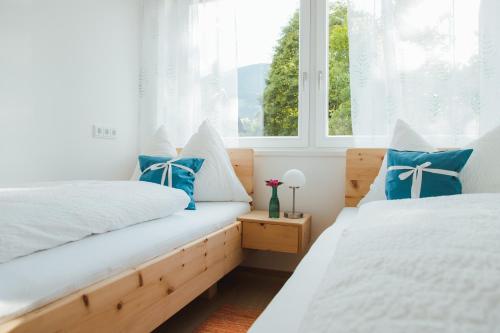 two beds in a room with two windows at Apart Rauchkofel in Lienz