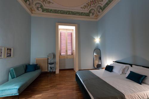 a bedroom with a large bed and a couch at Palazzo Francesco Grassi in Aradeo