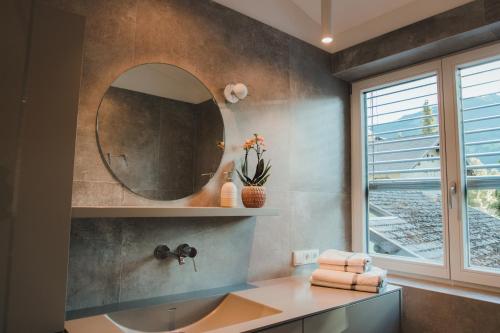 a bathroom with a sink and a mirror at Apart Rauchkofel in Lienz