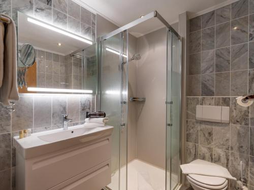 a bathroom with a shower and a sink and a toilet at Apparthotel Tom Sojer in Ellmau