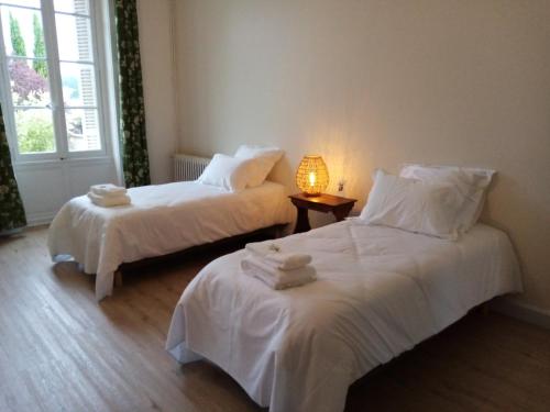 - 2 lits avec des draps blancs dans une chambre avec une lampe dans l'établissement Domaine de Pladuc, à Lachaise