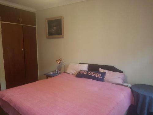 a bedroom with a bed with a pink blanket at 54 Martjie laan in Brits
