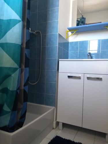 une salle de bain avec un lavabo, une baignoire et une douche dans l'établissement horizon sur mer 1137, à Saint Pierre La Mer