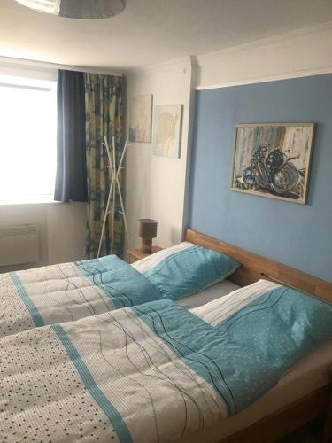 ein Schlafzimmer mit 2 Betten und einer blauen Wand in der Unterkunft Haus Pförtner in Westerland