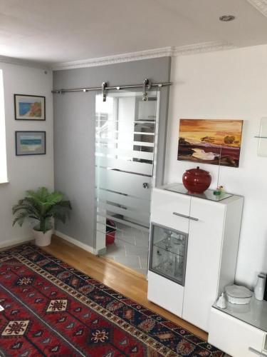 ein Wohnzimmer mit einer Glastür mit einer Pflanze in der Unterkunft Haus Pförtner in Westerland