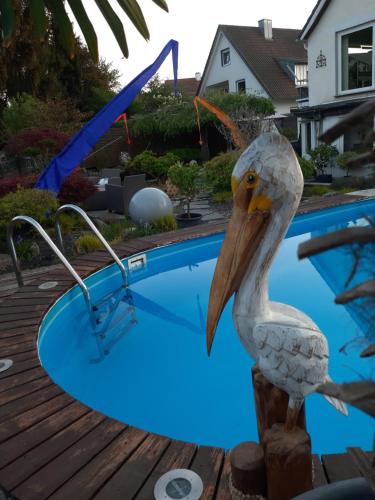 a statue of a pelican standing next to a swimming pool at Haus Steffi in Müllheim