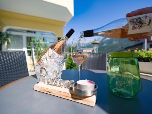 a bottle of wine is being poured into a glass at Apparthotel Tom Sojer in Ellmau