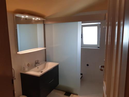 a bathroom with a sink and a toilet and a window at Apartments Bellavista in Rovinjsko Selo