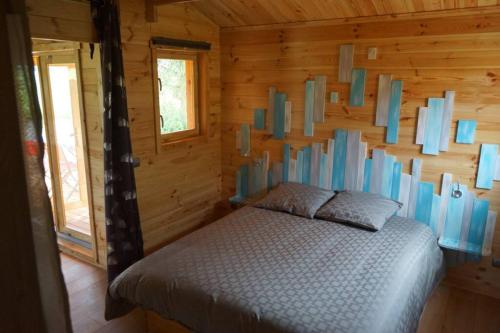 um quarto com uma cama num chalé de madeira em Chalet au Natur'Heil Nature-Spa-Gourmandise em Wahlbach