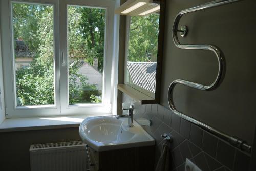 Un baño con lavabo y ventana. en Apartments Livia, en Jūrmala