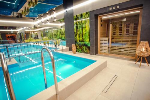 a pool in a building with a swimming pool at Srebrny Bucznik Wellness & Restaurant in Istebna
