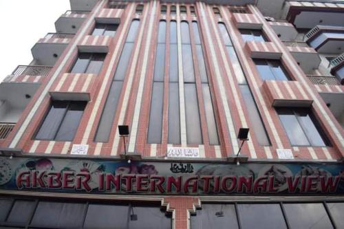 een hoog gebouw met een bord ervoor bij Akbar International View Hotel in Muzaffarabad