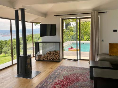 a living room with a fireplace with a view of a pool at Villa The View in Koper