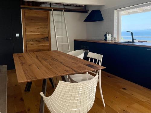 een keuken met een houten tafel en stoelen bij Villa The View in Koper