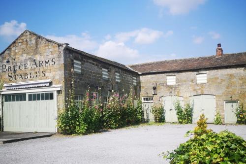 un edificio de ladrillo con puertas blancas de garaje y flores en The Bruce Arms, en Ripon