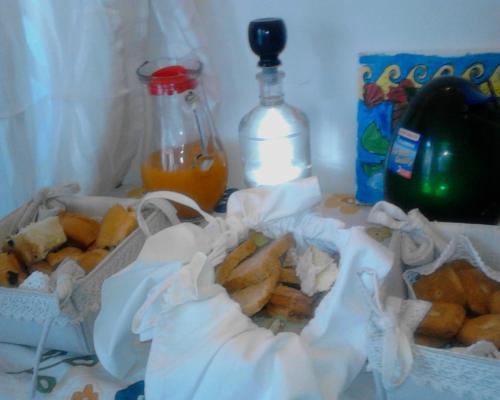 a table with a basket of food and a bottle of orange juice at B&B Ma Maison in Govone