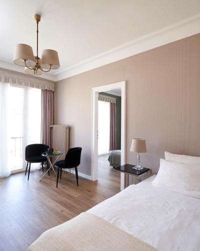 a bedroom with a bed and a table and chairs at Hotel Monopol - Central Station in Frankfurt/Main