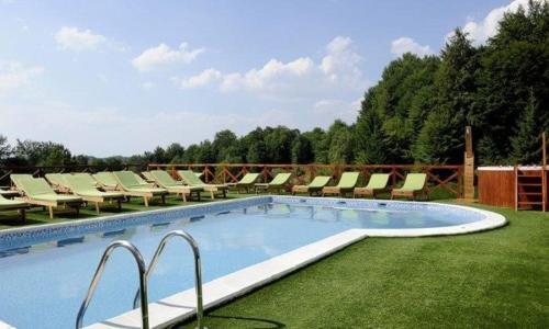 a large swimming pool with lounge chairs on the grass at Lux apartment A38, Kraljevi čardaci, Kopaonik in Kopaonik