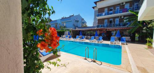 a swimming pool with chairs and a hotel at garden alis hotel in Fethiye