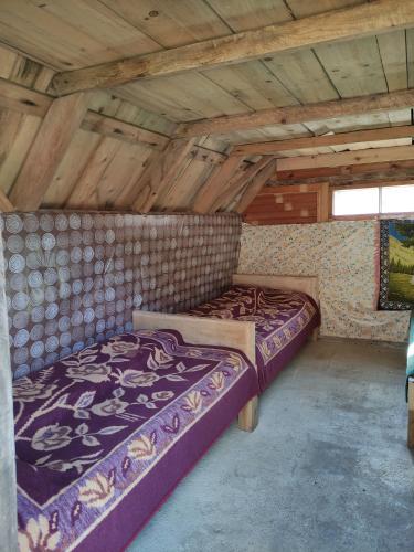 a large bed in a room with wooden ceilings at Dulović - KATUN POTOCI in Kolašin
