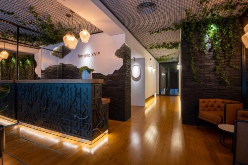 a lobby of a restaurant with a bar with plants at Ferraria XVI FLH Hotels Lisboa in Lisbon