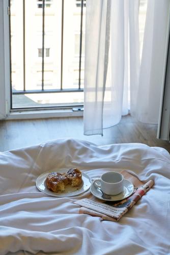 a plate of donuts and a cup of coffee on a bed at Hotel Monopol - Central Station in Frankfurt/Main