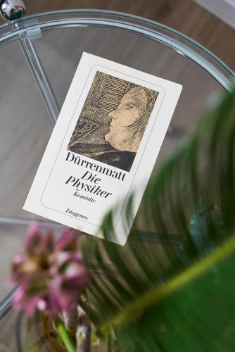 a book sitting on top of a vase with flowers at Hotel Monopol - Central Station in Frankfurt/Main
