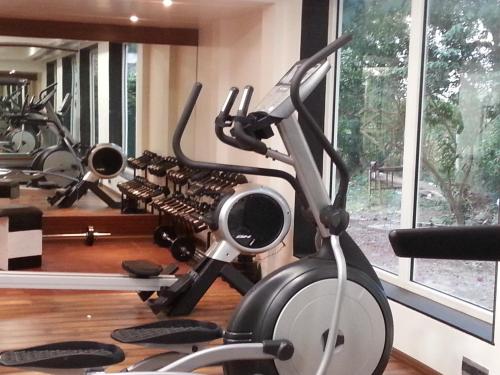 a gym with a treadmill and a row of exercise bikes at The Meadows Resort and Spa in Aurangabad