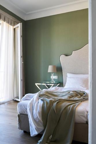 a bedroom with a bed with a green wall at Hotel Monopol - Central Station in Frankfurt/Main