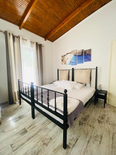 a bedroom with a large bed with a wooden ceiling at Joyas cosy apartment in Tragaki