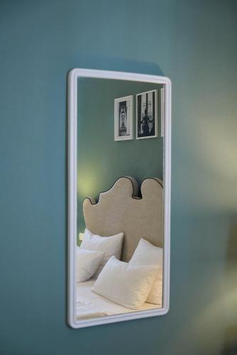 a mirror reflecting a bed with pillows on it at Hotel Monopol - Central Station in Frankfurt/Main