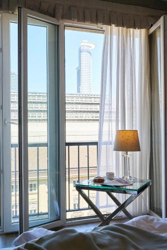 a bedroom with a table in front of a large window at Hotel Monopol - Central Station in Frankfurt/Main