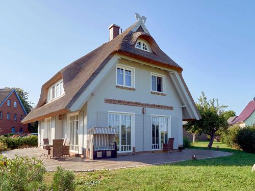 uma casa com telhado de palha e telhado de palha em Reethus Reddevitz F 402 mit Kamin, Sauna, Terrasse, Boddenblick em Alt Reddevitz