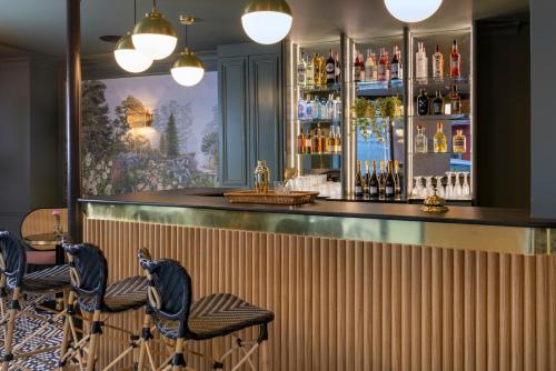 bar z dwoma niebieskimi stołkami przed ladą w obiekcie Hotel Fior d'Aliza w Paryżu